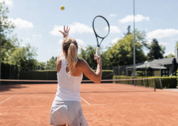 Tennisser die opslaat op een gravelbaan