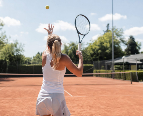 Tennisser die opslaat op een gravelbaan