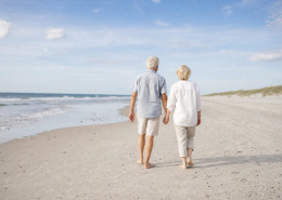 Ouder stel wandelt hand in hand over het strand