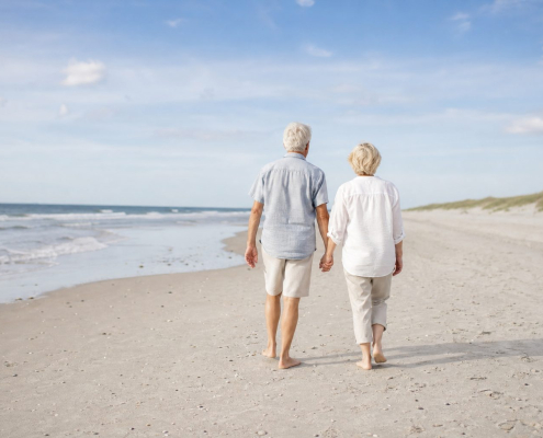 Ouder stel wandelt hand in hand over het strand