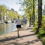 Hardloper langs een Amsterdamse gracht in de ochtend