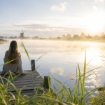 Rustig meer met een steiger bij zonsopkomst