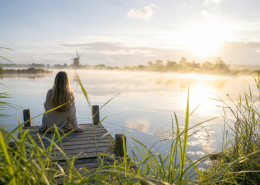Rustig meer met een steiger bij zonsopkomst