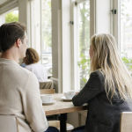 Twee ondernemers in een rustig gesprek aan een tafel bij het raam